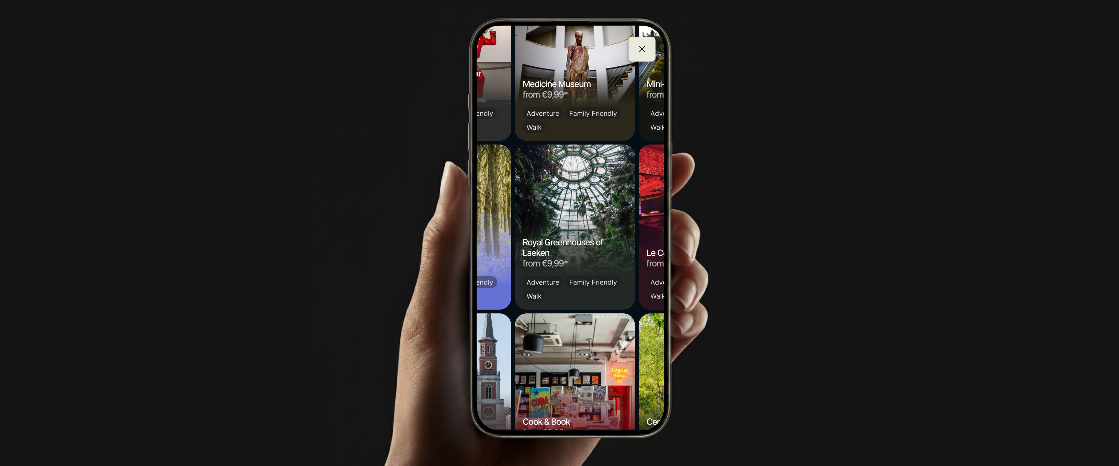 A hand holding a smartphone displaying the redesigned SNCB app with a mosaic interface of destinations